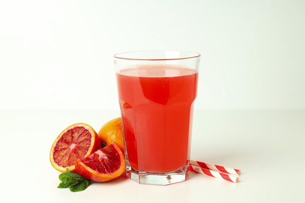 Concept of fresh drink with red orange juice on white table