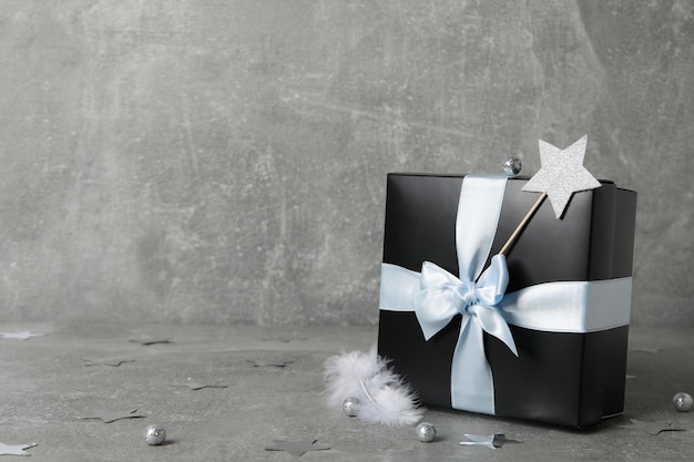 Concept of gift on gray textured table black gift box