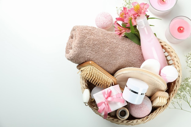 Concept of gift with basket of cosmetics on white background