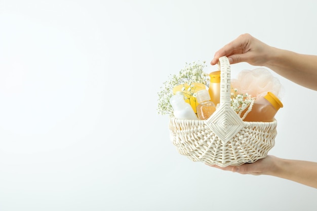 Concept of gift with basket of cosmetics on white background