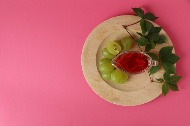 Concept of grape vinegar on pink background