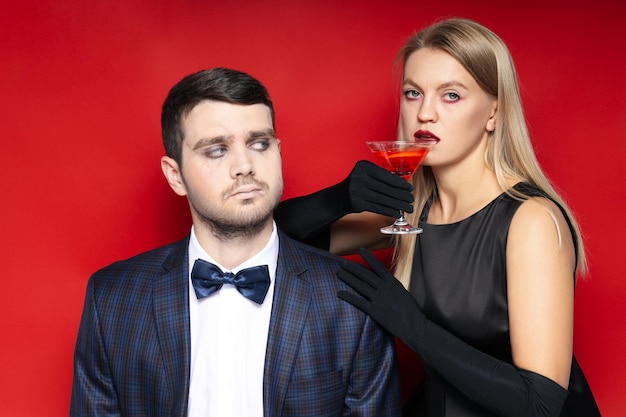 Photo concept of halloween young man and woman on red background