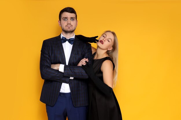 Concept of halloween young man and woman on yellow background