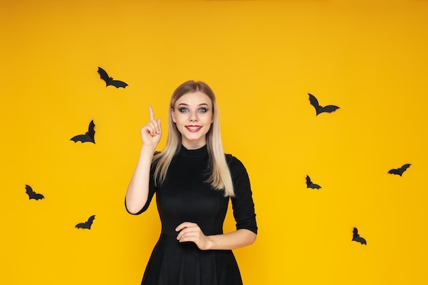 Concept of halloween young woman on yellow background