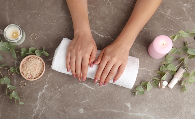 Concept of hand care with cosmetics on gray textured background