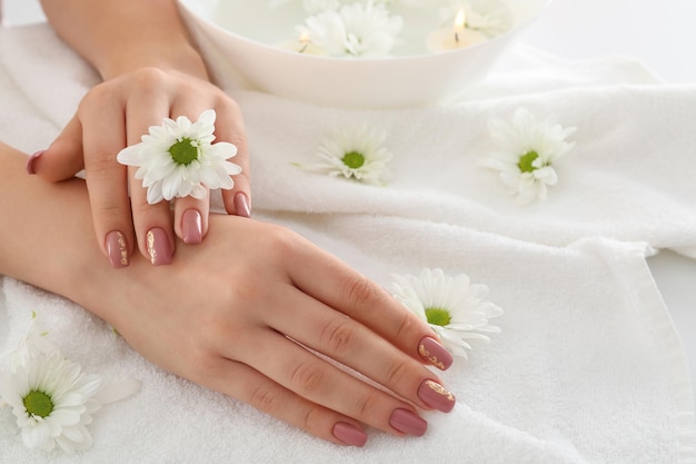 Concept of hand care with cosmetics on white towel background