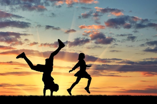 Concept of happiness. Silhouette of happy children on a sunset background