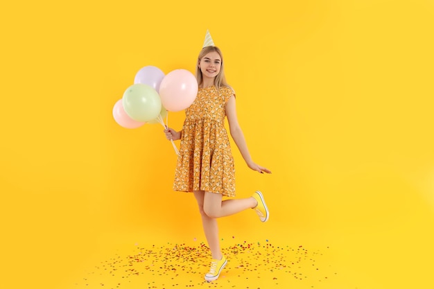 Concept of Happy Birthday with attractive girl on yellow background