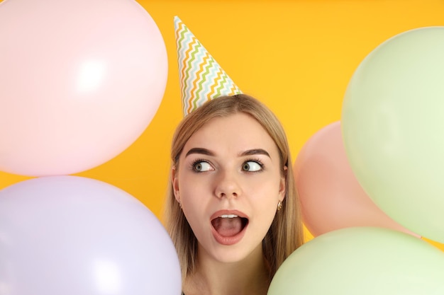 Concept of Happy Birthday with young woman on yellow background