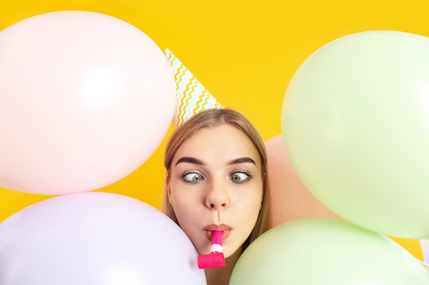 Concept of Happy Birthday with young woman on yellow background
