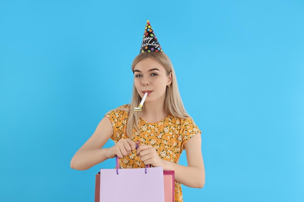 Concetto di giovane donna di buon compleanno su sfondo blu