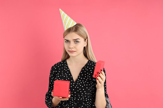 ピンクの背景に誕生日おめでとう若い女性の概念