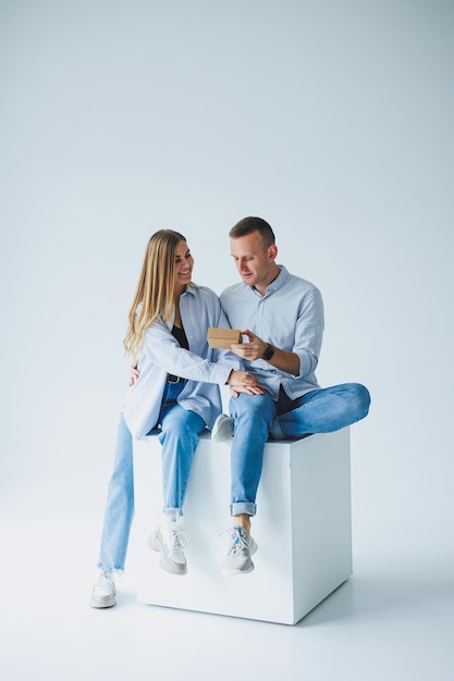 Concept of happy couple wearing white shirts blue jeans isolated white background A man and a woman are hugging on a white background Emotions of joy