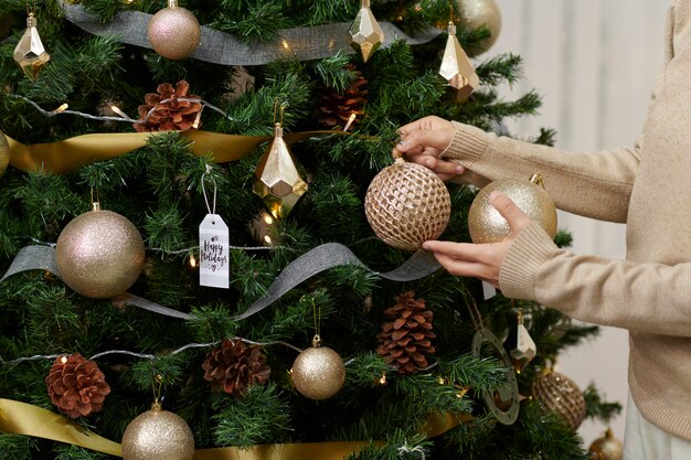 The concept of a happy holiday near the Christmas tree with decor in the home interior.