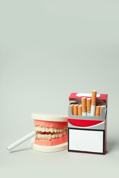 Concept of harm of smoking for teeth on light background