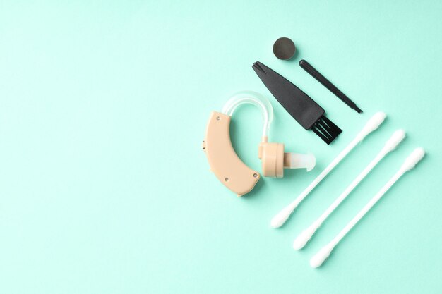 Concept of health care with hearing aid on mint background