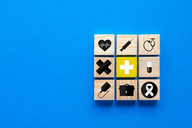 Photo concept of health insurance, wooden blocks with blue medical symbols, copy space