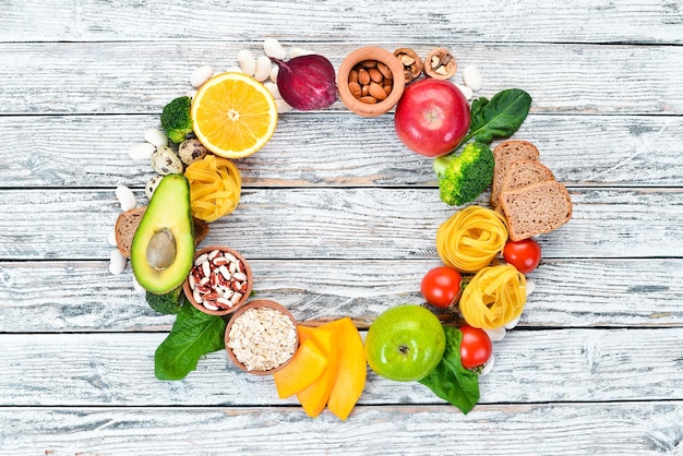 Foto concetto di cibo sano: pane, pasta, avocado, farina, zucca, broccoli, fagioli, spinaci. frutta e verdura. vista dall'alto. spazio di copia gratuito.