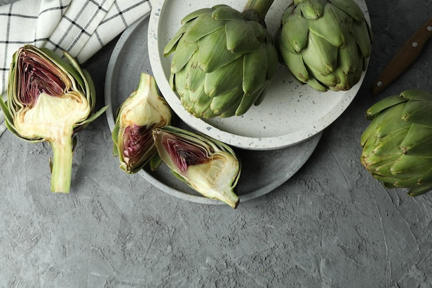 Concept of healthy food with artichoke on gray textured table