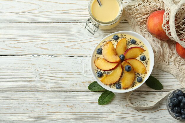 Concept of healthy food with peach yogurt on white wooden table