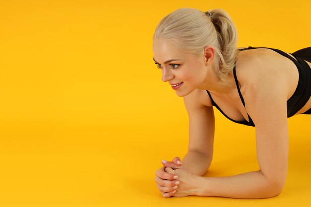 Concept of healthy lifestyle with sporty woman on yellow background