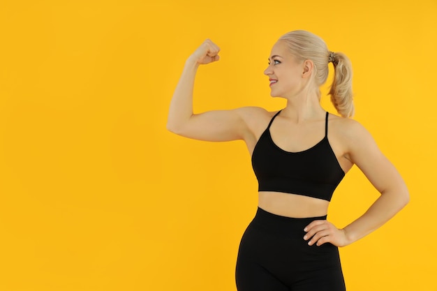 Concept of healthy lifestyle with sporty woman on yellow background