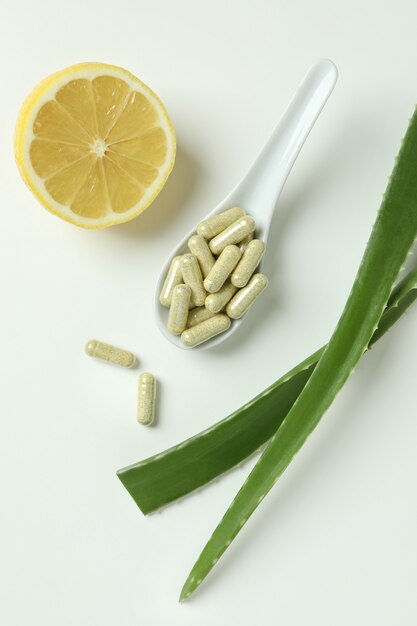 Concept of herb pills with aloe on white background