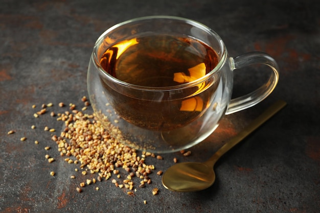 Concept of hot drink with buckwheat tea on dark textured background