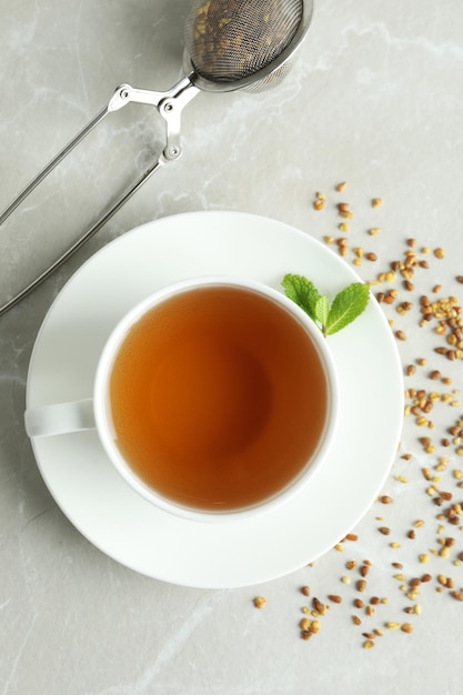 Concept of hot drink with buckwheat tea on light textured table