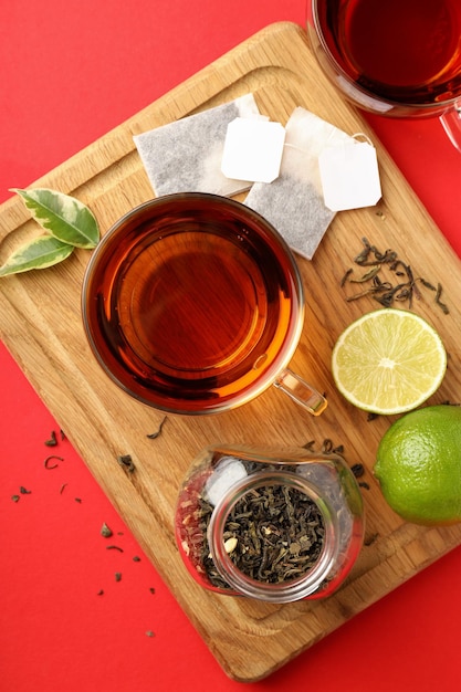 Concept of hot drink with tea on red background