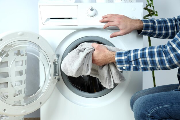 Concept of housework with washing machine and guy on white background