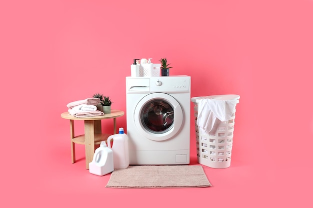 Concept of housework with washing machine on pink background