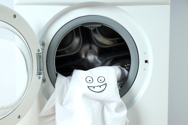 Concept of housework with washing machine on white background