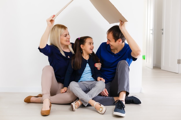 concept housing a young family. Mother father and child in new house with a roof