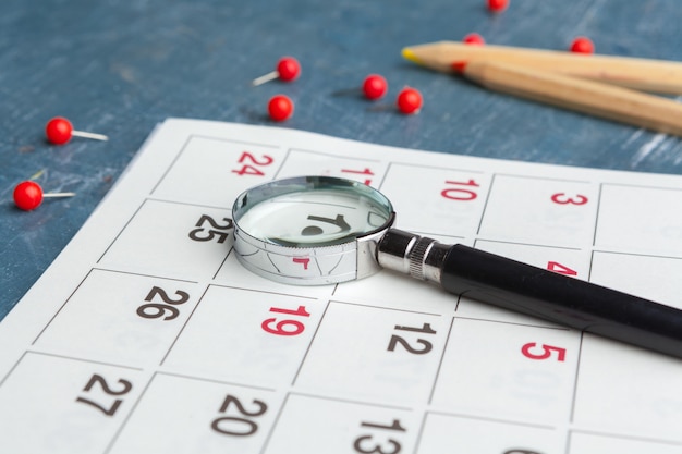 Concept image of business and meetings. Calendar to remind you an important appointment and Magnifying glass