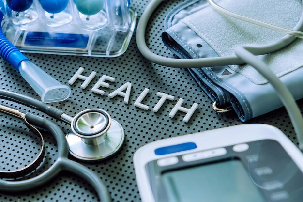 写真 健康の背景の概念 灰色の背景に描かれた健康の文字と医療機器
