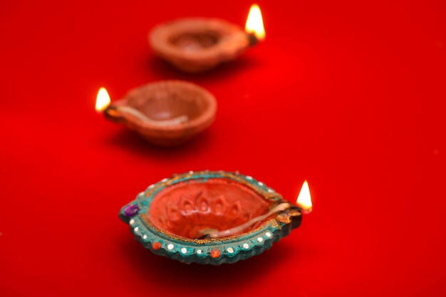 Concept of indian festival diwali Traditional oil lamps on Red background