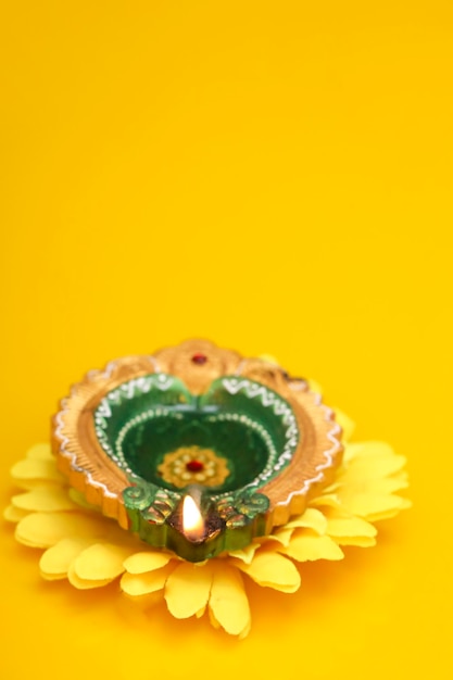 Concept of indian festival diwali Traditional oil lamps on yellow background