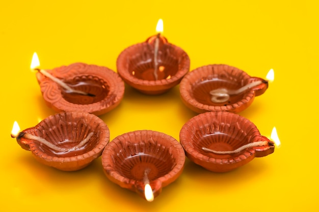 Concept of indian festival diwali Traditional oil lamps on yellow background