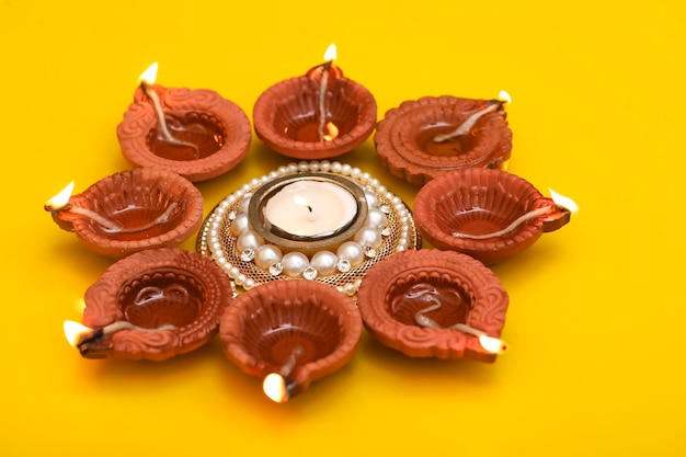 Concept of indian festival diwali Traditional oil lamps on yellow background