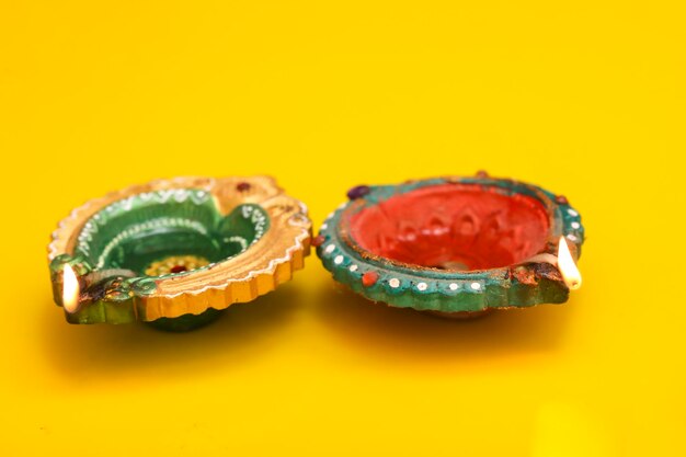 Concept of indian festival diwali traditional oil lamps on yellow background