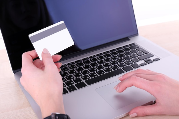 Concept for Internet shopping hands with laptop and credit card