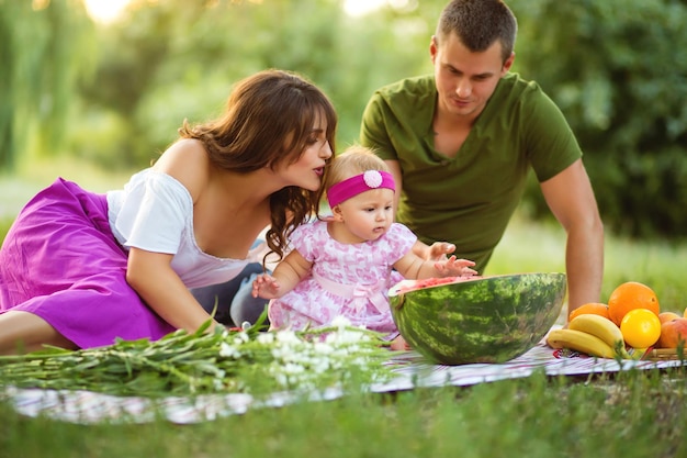 The concept of joint pastime Cute family picnicking in the park