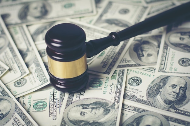 Photo concept of legal court gavel on assorted cash close up