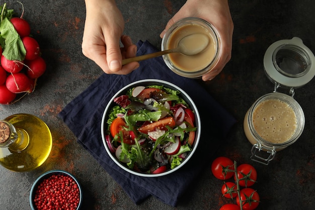 Concept lekker eten met groentesalade met tahinisaus op donkere gestructureerde achtergrond