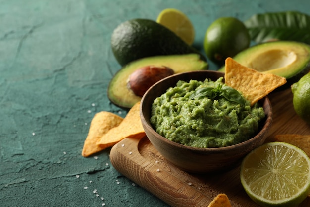 Concept lekker eten met kom guacamole op groene gestructureerde achtergrond