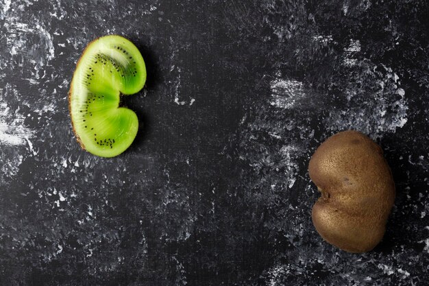 Foto concept lelijke groene vruchten worden gesneden en liggen tegenover op een zwarte achtergrond