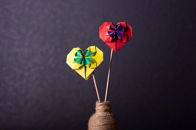 Concept liefde handgemaakte papercraft origami bewerkte gekleurd papier hart close-up shot in studio geel en rood