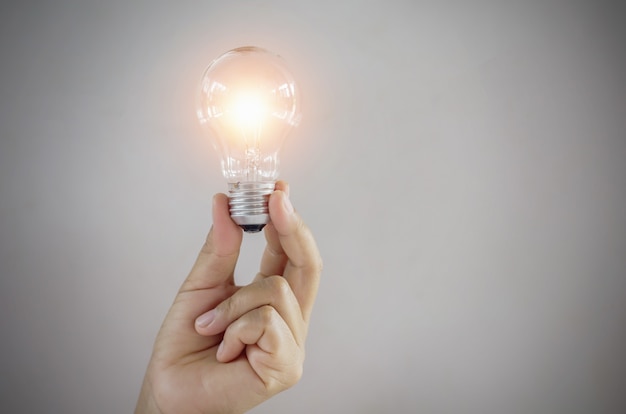 Photo concept light bulb in hand woman showing