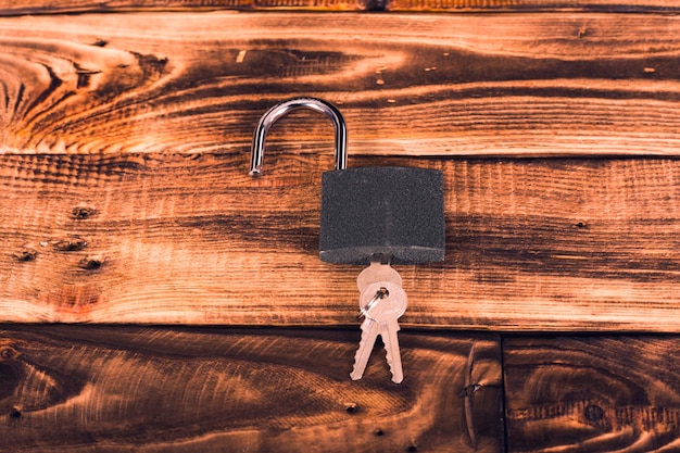 Foto concetto di una serratura con chiavi su uno sfondo di legno